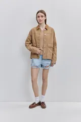 Campera de gabardina tostada, con cuello camisero de pana marrón, cierre frontal de botones metálicos y bolsillos delanteros aplicados con solapa.