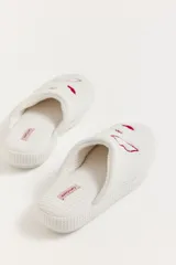 Pantuflas de tela waffle color blanco con bordados de labios rojos y la frase 'kiss me'.