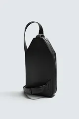 Bandolera negra de formato vertical con textura, diseño geométrico y correa ajustable para llevar al hombro.