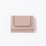 Billetera de cuero sintético beige, diseño compacto de tres pliegues con solapa frontal decorada con ribete metálico dorado y costuras pespunteadas.