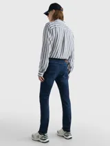 Pantalón de jean Tommy Hilfiger modelo Bleecker, corte slim, color azul oscuro. Confeccionado en tejido denim Power Stretch de mezcla de algodón, con efecto desteñido en las rodillas, estilo de cinco bolsillos y logo bordado en el bolsillo trasero.