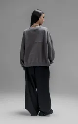 Buzo de cuello redondo confeccionado en frisa de algodón, con diseño de hombros caídos y logo bordado en el frente. Presenta terminaciones en punto rib en cuello, puños y ruedo.