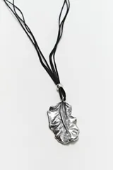 Collar con cordón de gamuza negro y dije de hoja plateada.