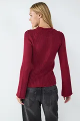 Sweater de punto color rojo con cuello redondo y mangas largas levemente acampanadas. Presenta diseño de rayas en contraste y ruedo recto.