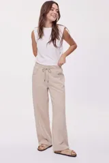 Babucha de calce relajado color beige, confeccionada en tejido de algodón con cintura elastizada, cordón de ajuste, bolsillos laterales y pernera amplia de estilo urbano.