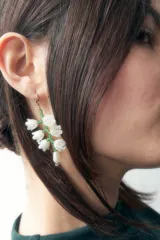 Aros colgantes con forma de ramillete de flores blancas con detalles en verde y perla. Cierre de gancho dorado.