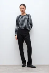 Remera de manga larga con diseño de rayas horizontales en blanco y negro, cuello redondo y corte clásico.
