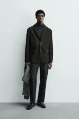 Blazer de corte regular confeccionado en piel con acabado de ante. Presenta cuello con solapas de muesca, cierre frontal de dos botones, bolsillos con solapa en la cadera y aberturas en la espalda.