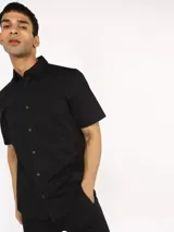 Camisa negra de manga corta con corte slim fit, cuello clásico y cierre con botones.