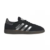 Championes adidas Handball Spezial de diseño clásico, confeccionados en gamuza negra con las icónicas tres tiras laterales en color plateado metalizado. Presentan una suela de goma color caramelo y detalles en el talón a tono.