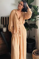 Conjunto de dos piezas color azul marino con finas líneas doradas metalizadas, compuesto por una camisa de manga larga con nudo frontal y un pantalón de corte amplio con cintura elástica.