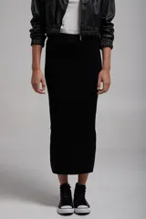 Pollera midi negra de tejido de punto, corte ajustado y largo hasta la pantorrilla.