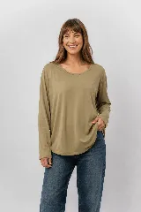Remera manga larga color verde militar, de cuello redondo amplio y calce relajado, con dobladillo inferior curvo.