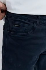 Pantalón de jean corte regular, color azul oscuro, con cierre de botón y cremallera, y bolsillos laterales y traseros.
