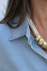 Camisa de jean en tono celeste claro, de corte holgado y diseño oversize. Presenta cuello clásico, cierre frontal con botones y mangas largas con puños con detalle de volado sutil.