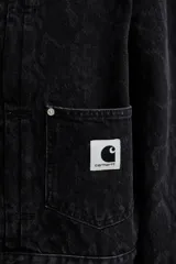 Chaqueta Carhartt modelo Belmar confeccionada en denim negro de alta densidad con sutil estampado de serpiente, cuello clásico, cierre frontal de botones metálicos, bolsillos frontales con solapa y etiqueta cuadrada con el logo de la marca.