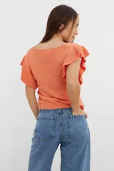 Sweater tejido de punto color coral, con cuello en V y mangas con volados.