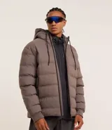 Campera puffer deportiva color marrón topo, con capucha ajustable con cordón y cierre frontal con cremallera.