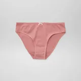Pack de siete bombachas de algodón con diseños variados, incluyendo estampados de vaquitas de San Antonio, flores y colores lisos, todas con un pequeño lazo decorativo en la cintura.