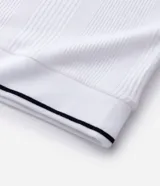 Remera polo blanca de viscosa texturizada con rayas, cuello y puños de mangas cortas en ribana con detalles contrastantes en negro.