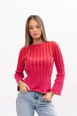 Buzo de punto acanalado con diseño de rayas verticales en tonos fucsia y rojo, de corte ajustado, cuello redondo y mangas largas ligeramente acampanadas.