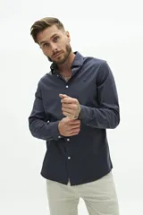 Camisa de manga larga con corte regular, confeccionada en una mezcla de lyocell y algodón. Presenta un diseño liso con cuello clásico, cierre frontal de botones y logo bordado en el pecho.