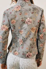Blazer de jacquard de algodón con estampado floreado, cuello subido, manga larga y cierre frontal con botones. Presenta bolsillos de plastrón en el delantero, detalle de aplicación de lentejuelas, forro interior a tono y bajo asimétrico.