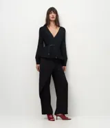 Pantalón de sastrería marca Cortelle, de corte recto y calce alineado al cuerpo. Presenta un diseño con cierre tipo cartera y superposición frontal que genera un efecto asimétrico, con cintura estructurada y botón lateral.