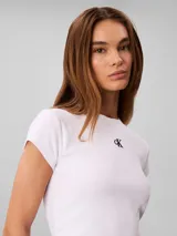 Remera baby fit de Calvin Klein, color blanco, confeccionada en tejido acanalado con cuello redondo y mangas cortas. Presenta el monograma de la marca bordado en el centro del pecho.