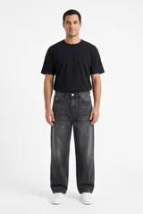 Pantalón jean baggy color gris oscuro con efecto gastado, de tiro medio y corte holgado en las piernas.