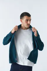 Camisa de viyela a cuadros negros, blancos y rojos, de corte slim fit, con bolsillos en el pecho, manga larga y cierre con botones.