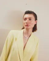 Dije en forma de estrella con diseño de cara sonriente, elaborado en metal plateado con dos pequeños cristales incrustados en los ojos.