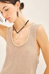 Top sin mangas de tejido de punto compacto con escote en U pronunciado. Presenta una textura sedosa y brillante, con un diseño ajustado al cuerpo.