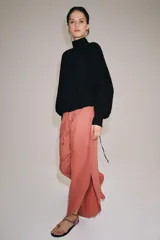 Pantalón confeccionado en lino 100%, de tiro medio con cintura elástica ajustable mediante cordones y bajo redondeado con aberturas laterales.