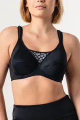 Soutien deportivo reductor negro con aro, confeccionado en jersey y tela de faja en la espalda para mayor sujeción. Breteles acolchados regulables, escote alto con detalle de puntilla y ganchos reforzados en la espalda.