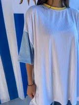 Remera de corte oversize confeccionada en tejido de punto acanalado color celeste, con mangas cortas en color amarillo y detalle de parche bordado con la bandera de Uruguay en la parte superior de la espalda.