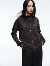 Cardigan de punto con escote en V y cierre frontal de botones. Presenta un diseño estampado de animal print con acabado brillante, mangas largas y corte holgado.