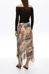 Falda midi de corte irregular con vuelo, confeccionada en viscosa. Presenta cierre lateral con cremallera invisible y tiras desflecadas que aportan movimiento y textura, con diseño estampado tipo patchwork.
