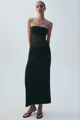 Vestido midi negro de escote palabra de honor, con diseño combinado de paneles de distintos acabados y detalle drapeado en la zona frontal y de la cintura. Cuenta con cierre lateral de cremallera oculta.