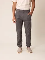 Pantalón bombacha de sarga color gris, confeccionado en mezcla de algodón y elastano, con pinzas en la cintura y puños elásticos en los tobillos.