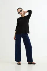 Sweater rosado de tejido de punto con escote en V y mangas largas con puños acanalados. El ruedo también es acanalado y presenta un detalle de crochet.