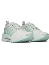 Championes Under Armour modelo UA W Phantom X, de color blanco con detalles en verde menta. Presentan parte superior de tejido transpirable, estructura de TPU translúcido en el mediopié con el logo de la marca, entresuela acolchada y suela de goma con tacos para tracción.