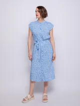 Vestido midi celeste con estampado floral blanco, corte camisero, cuello mao, manga corta y lazo en la cintura.