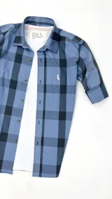 Camisa de algodón a cuadros azules y negros, con mangas largas y cuello clásico.