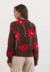 Cardigan de punto color chocolate con estampado de flores rojas, escote en V, cierre frontal con botones y puños y ruedo acanalados.