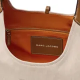 Bolso tipo hobo de Marc Jacobs, modelo The Belted Sack, confeccionado en lona color beige con detalles en cuero marrón. Presenta el logo de la marca grabado en el frente y una forma relajada con cierre ajustable.
