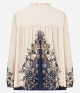 Blusa tipo bata de viscosa con estampa floral estilo paisley. Presenta cuello alto con detalle de volados, cierre frontal con botones y lazo ajustable en el escote. Posee mangas largas abullonadas con puños elásticos.