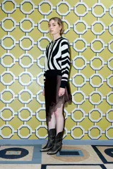 Sweater de punto con estampado de rayas onduladas en blanco y negro, cuello polo con botones y mangas largas.