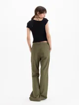 Pantalon cargo de tiro alto color verde militar, confeccionado en sastrero elastizado, con multiples bolsillos con tapa en los laterales y diseño de pernera ancha.