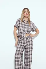 Pantalón de tiro alto, pierna amplia y caída fluida, con estampado de cuadros en tonos blanco, negro y marrón oscuro.